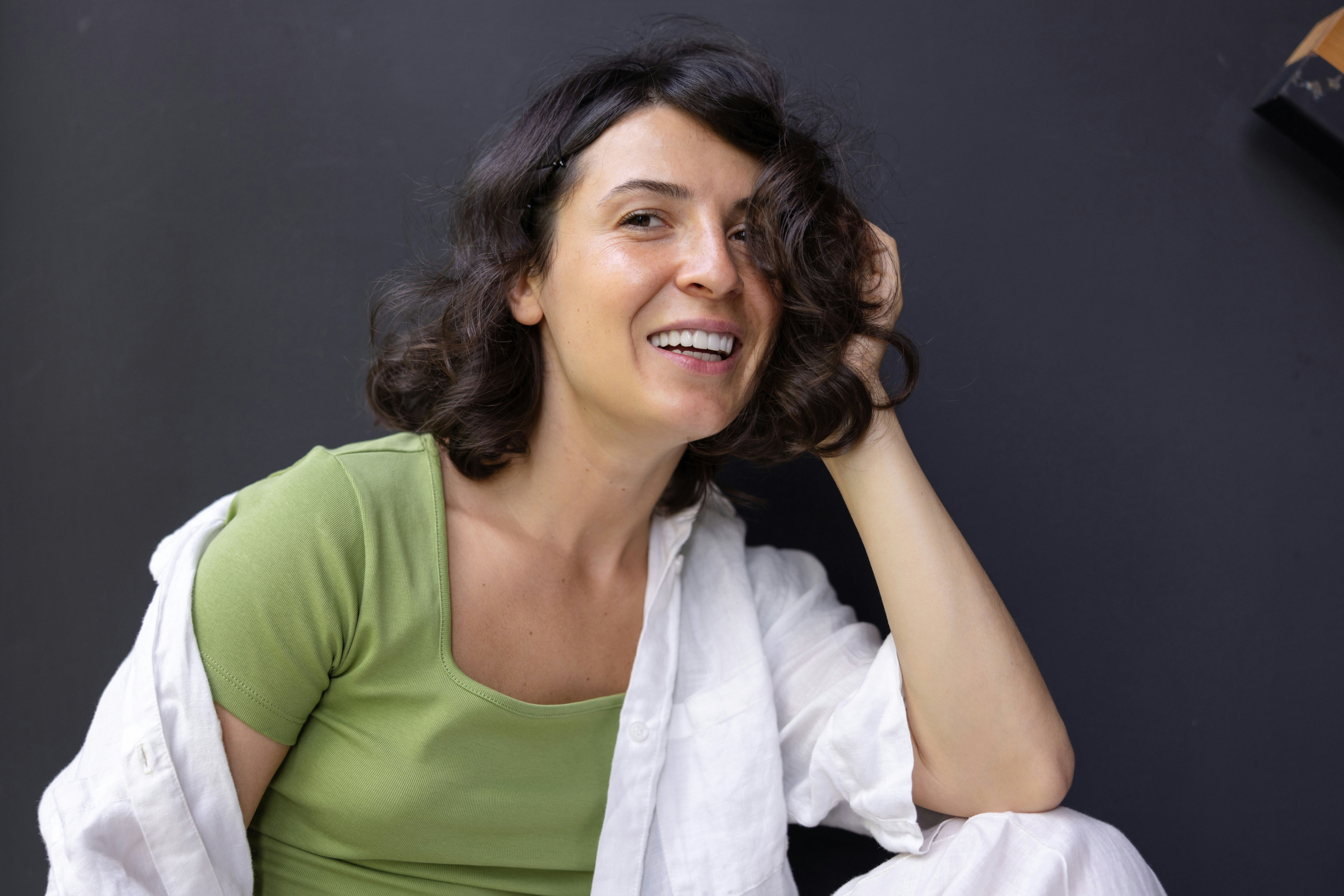 Smiling woman with full, curly shoulder-length hair